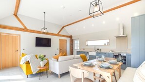 A modern living room with a sofa, dining table, and kitchen area. - 2 Bed in Beeford (oc-t90892) (Beeford)