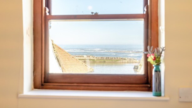 Een uitzicht op zee, met een betonnen muur.
