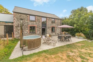 A stone house with a patio, outdoor seating, and a hot tub. - 3 Bed in Milltown (oc-c30983) (Milltown)