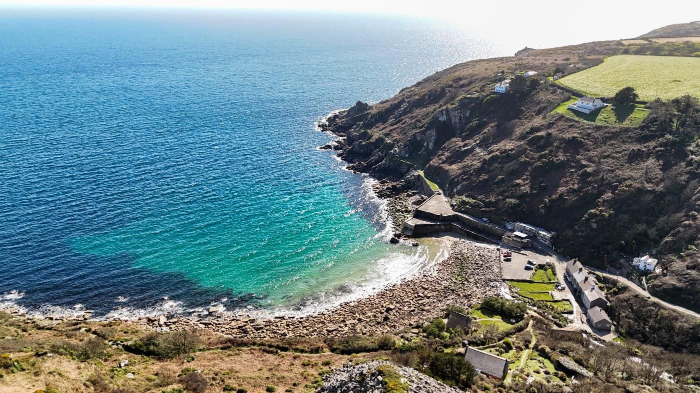 A coastal property with a rocky shoreline, a fortified structure, and several buildings with distinct architectural styles.