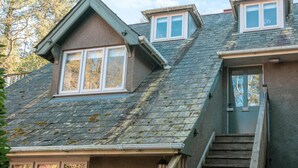 A two-story house with a steeply pitched roof, dormer windows, and a front door with a small porch. - 2 Bed in East Anstey (oc-k31022) (East Anstey)