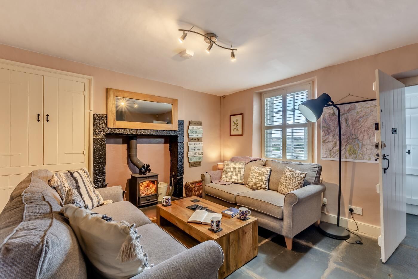 Ein gemütliches Wohnzimmer mit Kamin, zwei Sofas, einem Couchtisch und einer Karte an der Wand.
