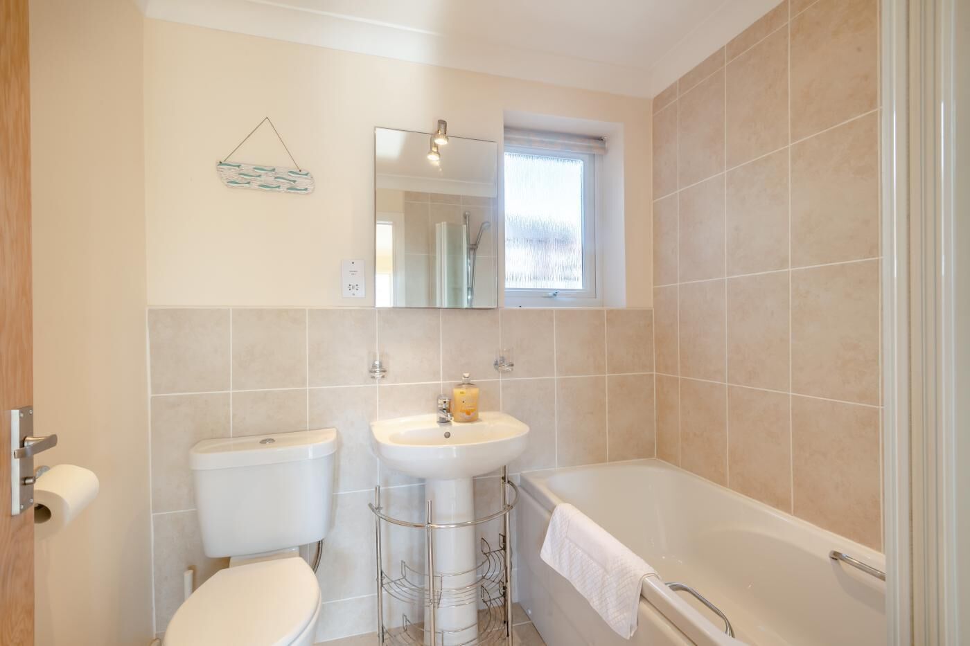 A bathroom with a toilet, sink, and bathtub.