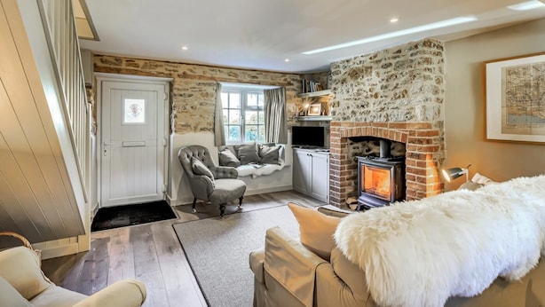 Una sala de estar acogedora con chimenea de piedra, un sofá cómodo y un televisor.