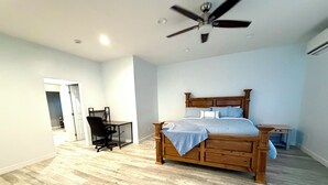 Un dormitorio con una cama de madera, un escritorio y una silla.