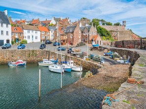 A harbor with boats docked, stone walls, and historic buildings. - 3 Bed in Kingsbarns (oc-k30925) (Kingsbarns)