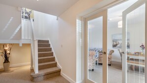 Un escalier menant à une chambre située en mezzanine, qui offre une vue sur l’espace de vie.