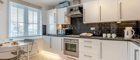 Mikrobølgeovn, ovn, oppvaskmaskin og høy barnestol