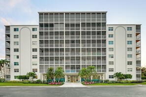A multi-story hotel with a symmetrical facade, balconies, and a central entrance. - Walk to Beach: Luxe Harbor-View Condo in Naples! (Naples)