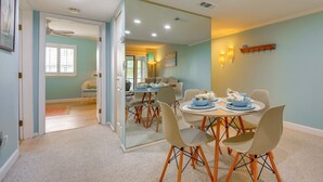 A dining area with a table set for four, surrounded by chairs with wooden legs.
