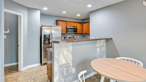 A modern kitchen with granite countertops, stainless steel appliances, and wooden cabinets. - 4BR Pet-Friendly Charlotte Home | 6 Mi to CLT (Charlotte)