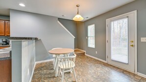 A kitchen with a granite countertop, a white dining table with chairs, a ceiling light, and a door with a window. - 4BR Pet-Friendly Charlotte Home | 6 Mi to CLT (Charlotte)