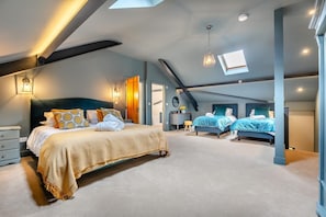 Ein geräumiges Schlafzimmer mit einem großen Bett, einem kleineren Bett und einem Schreibtisch.