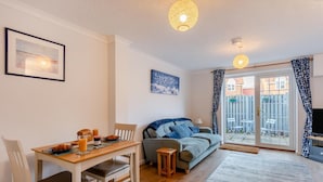 A cozy living room with a dining table, a sofa, and a TV. - 2 Bed in Snettisham (oc-d31668) (Snettisham)
