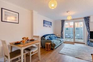A cozy living room with a dining table, a sofa, and a TV. - 2 Bed in Snettisham (oc-d31668) (Snettisham)