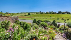 A garden with a variety of flowers and a brick wall. - 2 Bed in Seaford (oc-l31115) (Seaford)