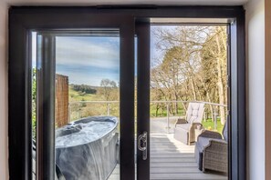 A hot tub on a deck with a view of a rural landscape. - 1 Bed in Berriew (oc-a31113) (Berriew)