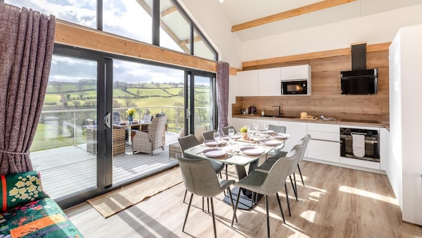 A modern kitchen with large windows, a dining area with a view, and a cozy seating area. - 4 Bed in Berriew (oc-t31114) (Berriew)