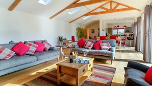 A spacious living room with high ceilings, a dining area, and a kitchen. - 3 Bed in South Cove (oc-r30975) (South Cove)