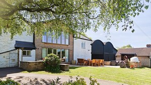 Een modern huis met een ruime patio, een eethoek en een garage.