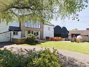 A modern house with a large patio, a dining area, and a garage.