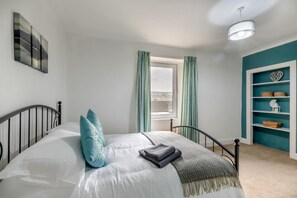 A bedroom with a bed, curtains, a window, and a shelf with decorative items. - 2 Bed in Hawick (oc-p30967) (Hawick)