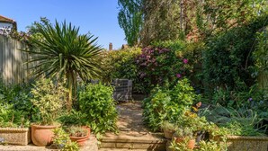 A garden pathway leading to a house with a wooden fence and various potted plants. - 2 Bed in Rye (oc-t31070) (Rye)