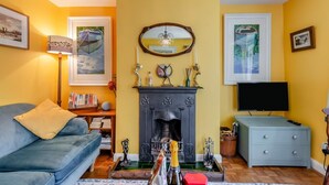 A living room with a fireplace, a sofa, a television, and framed artwork on the walls. - 2 Bed in Rye (oc-t31070) (Rye)