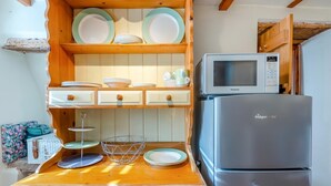 A compact kitchen with a microwave, refrigerator, wooden cabinets, and a sink. - 1 Bed in Starkholmes (oc-q30994) (Matlock Bath)