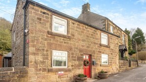 A stone building with a red door, windows, and a 'No Parking' sign. - 1 Bed in Starkholmes (oc-q30994) (Matlock Bath)