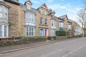 Une rangée de maisons mitoyennes avec des bow-windows et une porte rouge.