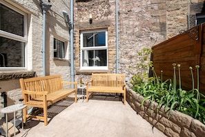 A stone building with a wooden bench and a small table. - 6 Bed in Buxton (oc-s31063) (Buxton)