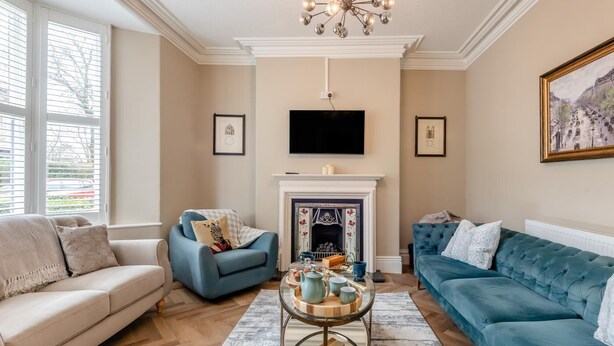 A living room with a fireplace, a television, and a sofa.