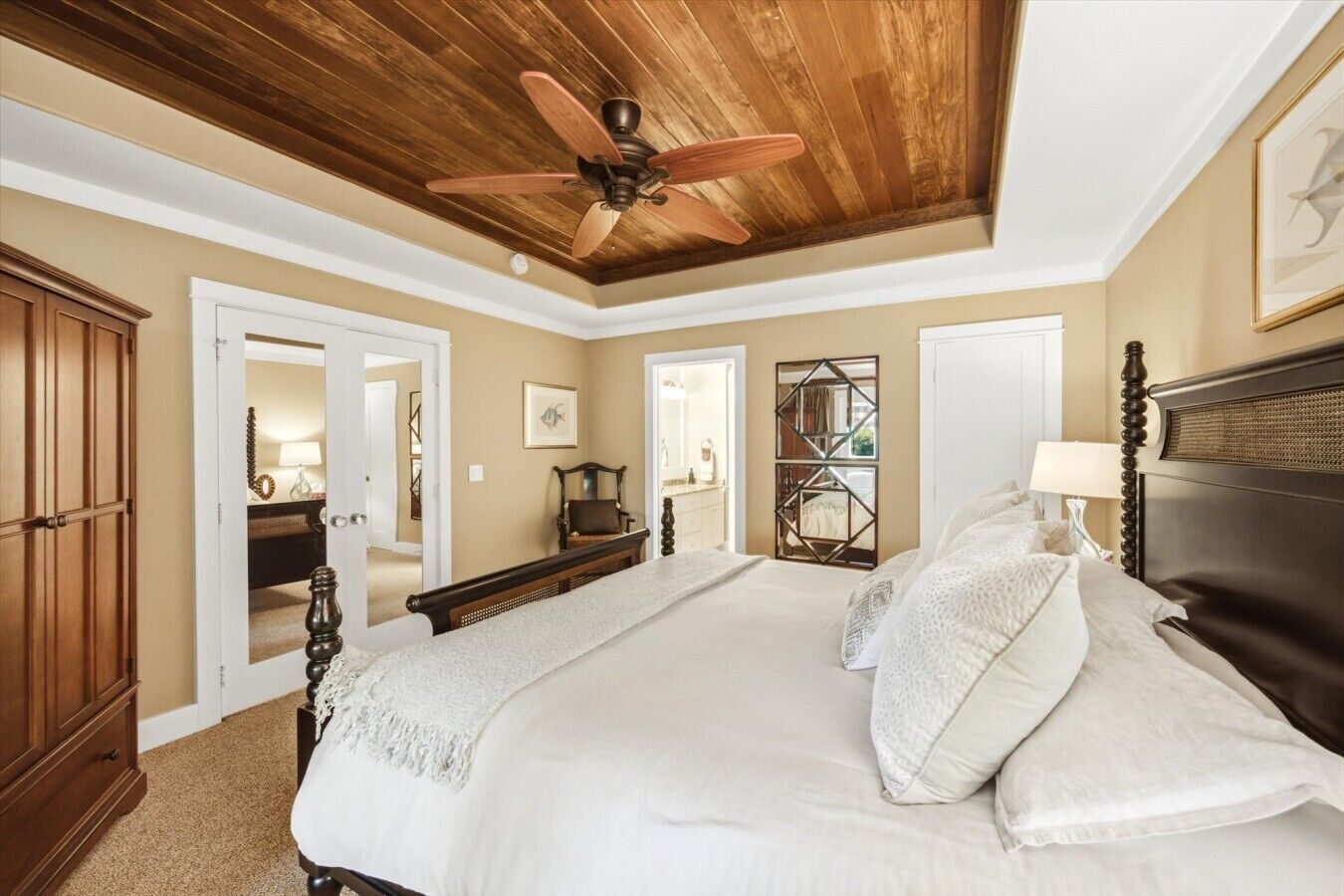 Une chambre à coucher avec un grand lit, un plafond en bois et un ventilateur de plafond.
