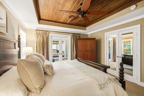 A bedroom with a large bed, a ceiling fan, a wardrobe, and a view of the outdoors through a door. - Lux Norris Lake Home|Private Dock & Stunning Views (LaFollette)