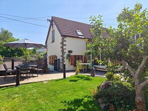 A house with a sloped roof, a patio with outdoor furniture, and a well-maintained garden. - 2 Bed in Ruardean (oc-a31749) (Ruardean)