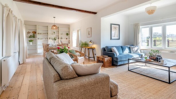 A spacious living room with a sofa, a coffee table, and a dining area with a table and chairs. - 5 Bed in Postwick (oc-w30947) (Postwick)