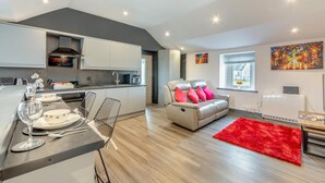 Un appartement moderne comprenant une cuisine, un coin repas et un salon.