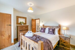 A bedroom with a wooden bed, bedside tables, a mirror, and a hanging light fixture. - 5 Bed in Litton (oc-l31793) (Litton)