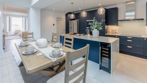 A modern kitchen with a central island, pendant lighting, and dark cabinetry. - 4 Bed in St. Ives (oc-p31118) (Saint Ives)