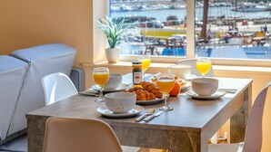 A breakfast table with croissants, orange juice, and a view of a marina. - 2 Bed in Whitby (oc-h31801) (Whitby)