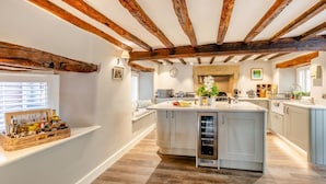 A spacious kitchen with a central island, wooden beams on the ceiling, and a built-in wine cooler. - 4 Bed in Cartmel (oc-d31802) (Cartmel)