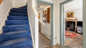 A staircase with blue carpeted steps, a wooden handrail, and a white wall. - 2 Bed in Windermere (oc-c31666) (Crook)