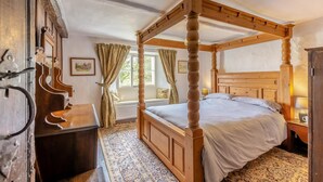 A four-poster bed with a wooden headboard, a wooden desk, and a patterned rug. - 3 Bed in Windermere (oc-b31667) (Crook)