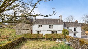 A two-story white house with a stone wall and a grassy yard. - 3 Bed in Windermere (oc-b31667) (Crook)