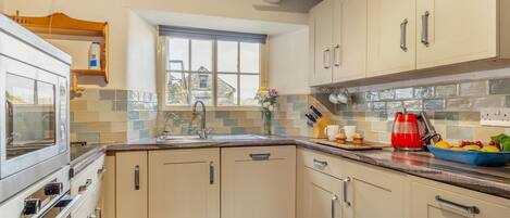 Forn, rentaplats, trona i utensilis de cuina, vaixella i coberteria