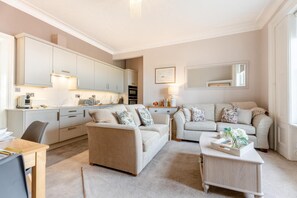Un salon moderne comprenant un ensemble de canapés, une table basse et un coin repas avec une table et des chaises.