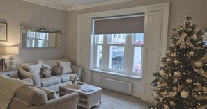 A living room with a sofa, coffee table, and a Christmas tree. - 2 Bed in Whitby (oc-e31738) (Whitby)