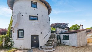 Ein einzigartiges, zylindrisches Haus mit einer Wendeltreppe, die zum Eingang führt.