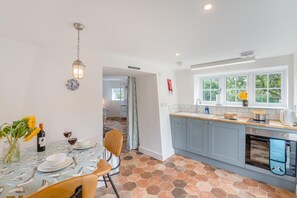 A modern kitchen with grey cabinets, a tiled backsplash, and a window with a view of greenery. - 1 Bed in Hornsea (oc-t31047) (Hornsea)